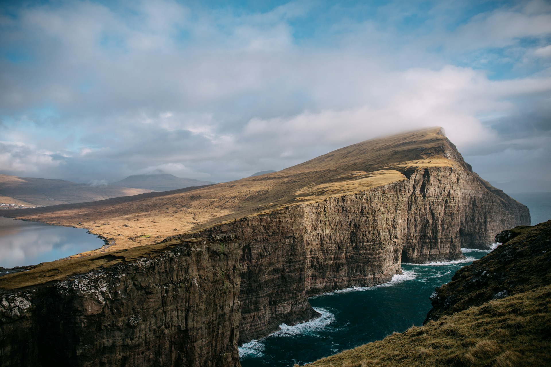 Photo looking at a massive cliff face with ocean below.